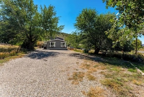 A house with a gravel driveway, surrounded by trees.