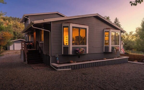 A single-story house with a front porch, a small attached garage, and a landscaped front yard. - Luxury Durango Retreat - Hot Tub, Views! (Durango)