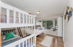 A room with bunk beds, a ladder, a window seat, and a wall with decorative plates. - Luxury Durango Retreat - Hot Tub, Views! (Durango)