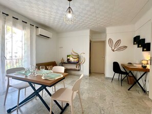 Ein moderner Essbereich mit Holztisch, Stühlen und einem Fernseher.