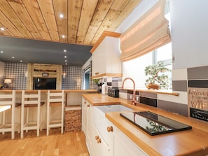 Una cocina moderna con armarios de madera, una isla integrada con un lavamanos y una ventana con vistas al exterior.