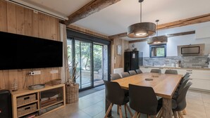Eine moderne Küche mit einer großen Kochinsel, Holzbalken und einem Essbereich mit einem großen Tisch und Stühlen.