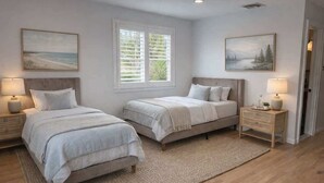 A bedroom with two beds, a large window with blinds, and artwork on the walls. - Pool Gym Biocharger Tennis Private bath All New BR (Southampton)