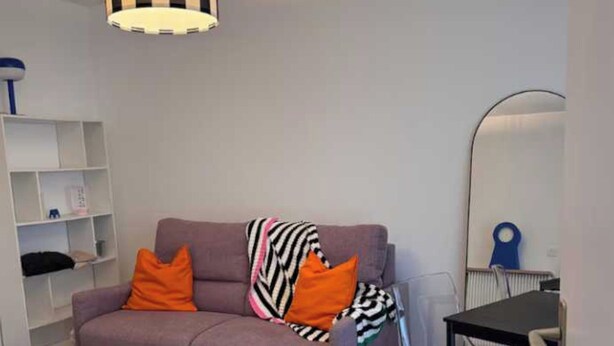 A living room with a sofa, a checkered rug, a desk, and a hanging lamp. - Vintage 2P Studio - Issy-les-moulineaux (Issy-les-Moulineaux)