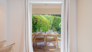 An open sliding door leading to an outdoor dining area with a table set for four, surrounded by chairs. - 6P Apartment in a Citadelle /pool - Saint-tropez (Saint-Tropez)
