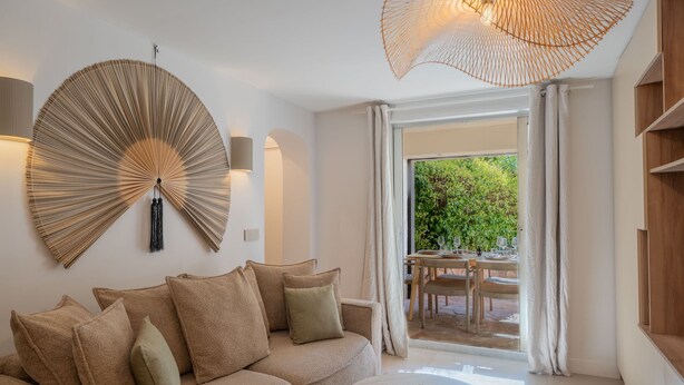 A modern living room with a sofa, a round coffee table, and a large wall fan. - 6P Apartment in a Citadelle /pool - Saint-tropez (Saint-Tropez)