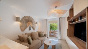 A modern living room with a sofa, a coffee table, a TV, and a dining area with a table and chairs. - 6P Apartment in a Citadelle /pool - Saint-tropez (Saint-Tropez)