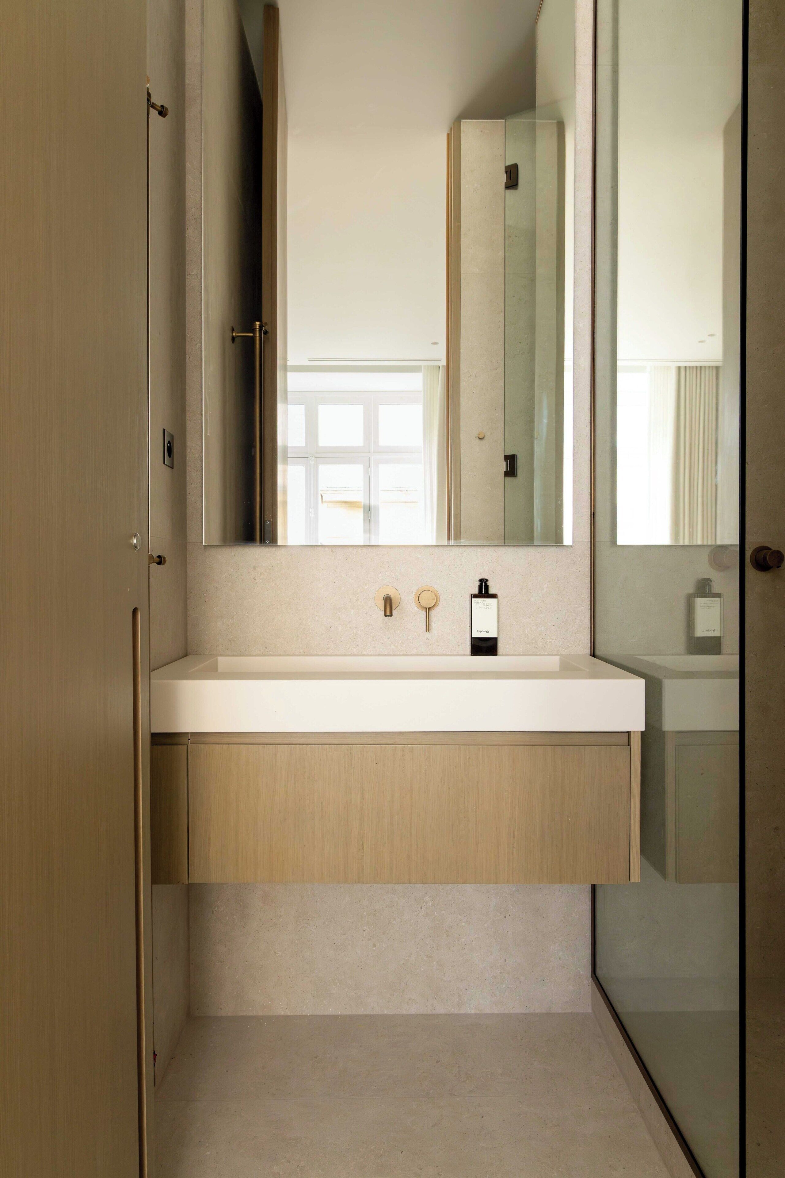 Une salle de bain moderne avec un grand miroir, un lavabo et un meuble de rangement.