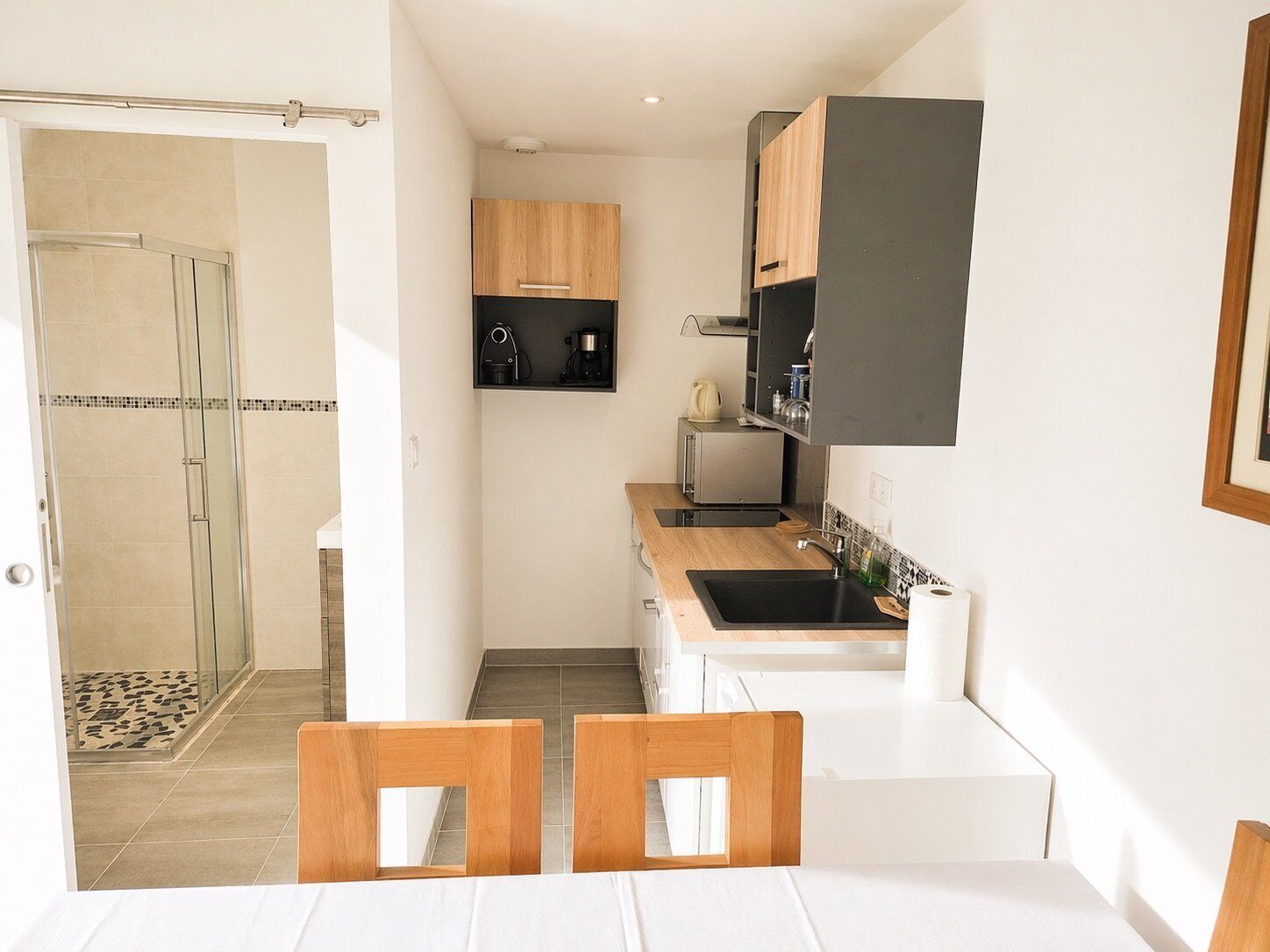 A compact kitchen with a built-in oven, a coffee maker, and a microwave.