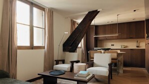 Ein modernes Wohnzimmer mit Sofa, Couchtisch und einer Treppe, die in eine Küche führt.