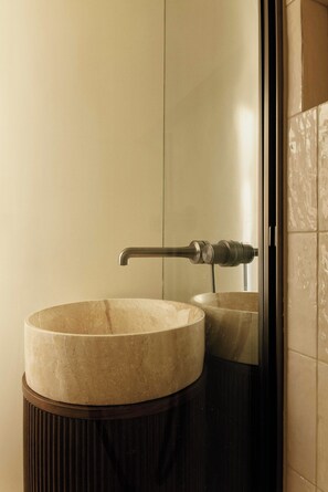 A bathroom with a round marble sink, a modern faucet, and a glass-enclosed mirror. - Cozy Apartment a/c 1br/4p - Tuileries (Paris)