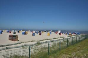 A beach with colorful beach huts and a clear sky. - NEW! Villa Totti - Anna's parlor (Neßmersiel)