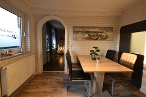 Eine moderne Küche mit einem Holztisch, schwarzen Stühlen und einer weißen Ziegelwand.