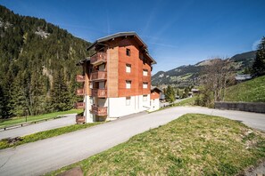 A multi-story wooden building with balconies, set in a mountainous area with a clear sky. - Mountain View Apartment - Châtel with Balcony, Wi-Fi, and Stunning Scenery (Châtel)