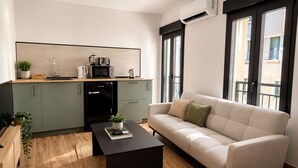 A modern living space with a kitchen, sofa, and coffee table. - Collection Las Ventas Apartamento G Cerca de la Plaza de Toros (Madrid)