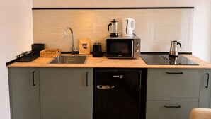 A compact kitchen with a sink, a toaster, a coffee maker, a microwave, and a dishwasher. - Collection Las Ventas Apartamento G Cerca de la Plaza de Toros (Madrid)