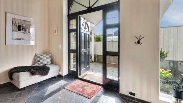A modern interior with a sofa, a rug, and a door leading outside. - Spacious villa with private pool, 5 bedrooms and 5 bathrooms (Rogaland)