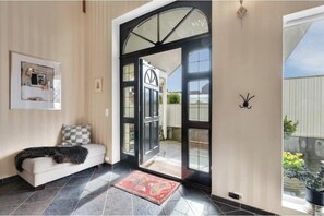 A modern interior with a sofa, a rug, and a door leading outside.