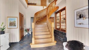 A wooden staircase leading to an upper floor, a white console desk, and a framed picture on the wall. - Spacious villa with private pool, 5 bedrooms and 5 bathrooms (Rogaland)