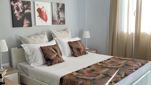Ein ordentlich eingerichtetes Schlafzimmer mit einem Bett, Nachttischen und Wandbildern.
