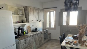 Eine Küche mit Kühlschrank, Spüle, Herd und Holzausstattung.