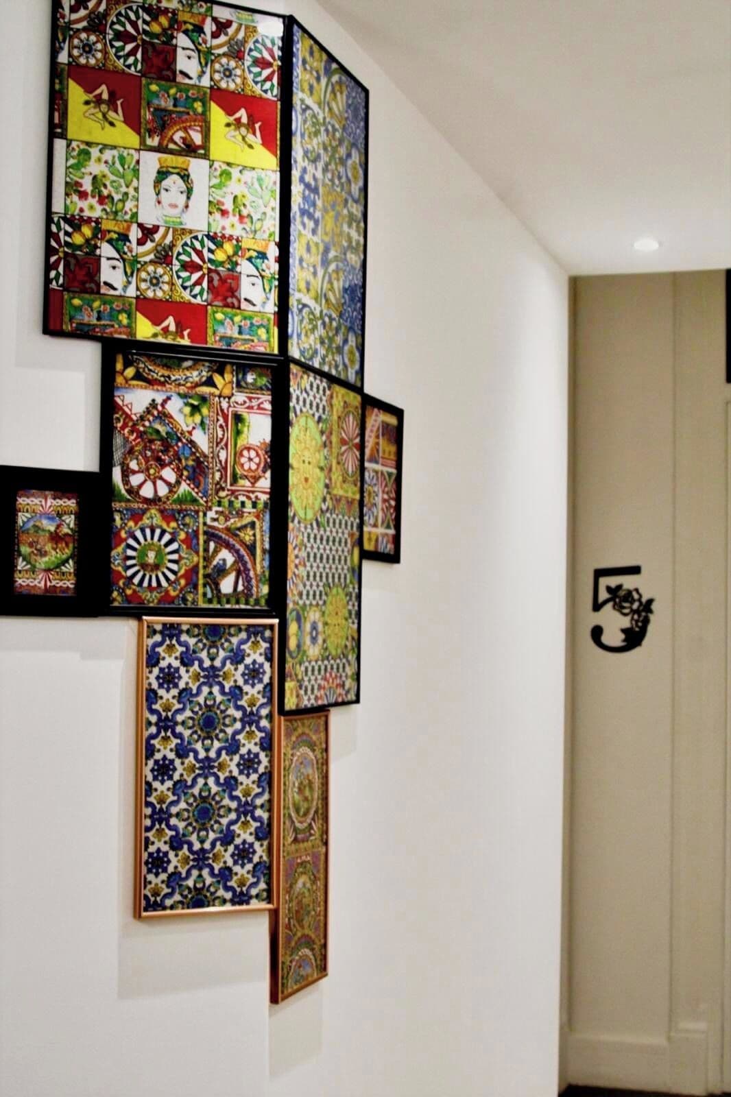 Een muur met een reeks inlijste tegels met verschillende patronen en designs.