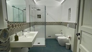 A modern bathroom with a glass shower enclosure, a white sink, and a toilet. - Le Suite Vintage Del Corso (Palermo)
