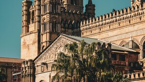 A historic building with intricate architecture, including a prominent tower and arches. - Le Suite Vintage Del Corso (Palermo)