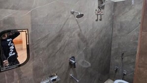 Kylpyhuone, jossa on pesuallas, peili, suihku ja wc.