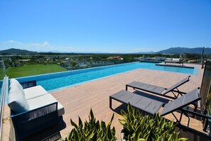 A rooftop pool area with lounge chairs and a view of the surrounding landscape. - Studio Shopping OKA Floripa - SOK211 (Florianópolis)