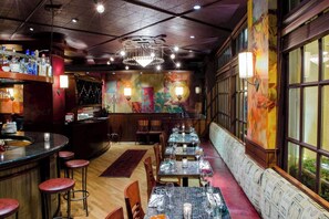 A restaurant with a bar area, tables with chairs, and a mural on the wall. - Mayflower Park | Classic 2 Queen | Walk to Dining, Landmark Hotel, Family Escape (Seattle)