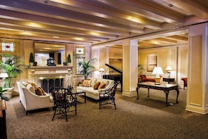 A spacious lobby with a fireplace, a grand piano, comfortable seating, and a well-lit ambiance. - Mayflower Park | Classic 2 Queen | Walk to Dining, Landmark Hotel, Family Escape (Seattle)