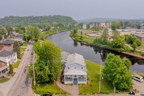 A river running through a residential area with houses and a small building with a porch.