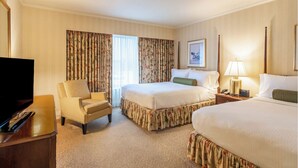 Une chambre d’hôtel avec un lit, une chaise, une télévision et une lampe.