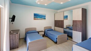A bedroom with two beds, a desk, a mirror, and a painting of a beach scene. - Apartment 'Casa Mariateresa' with Mountain View, Wi-Fi, and Air Conditioning (Vico Equense)