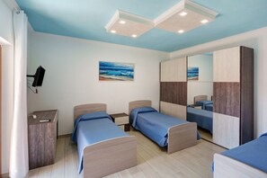 Een slaapkamer met twee bedden, een bureau, een spiegel en een schilderij van een strand.