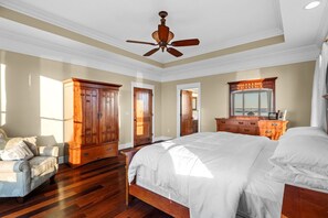 A bedroom with a large bed, wooden wardrobe, and a ceiling fan. - Family Retreat ~ Waterfront Luxury Home Sleeps 26 Comfortably (Centre)