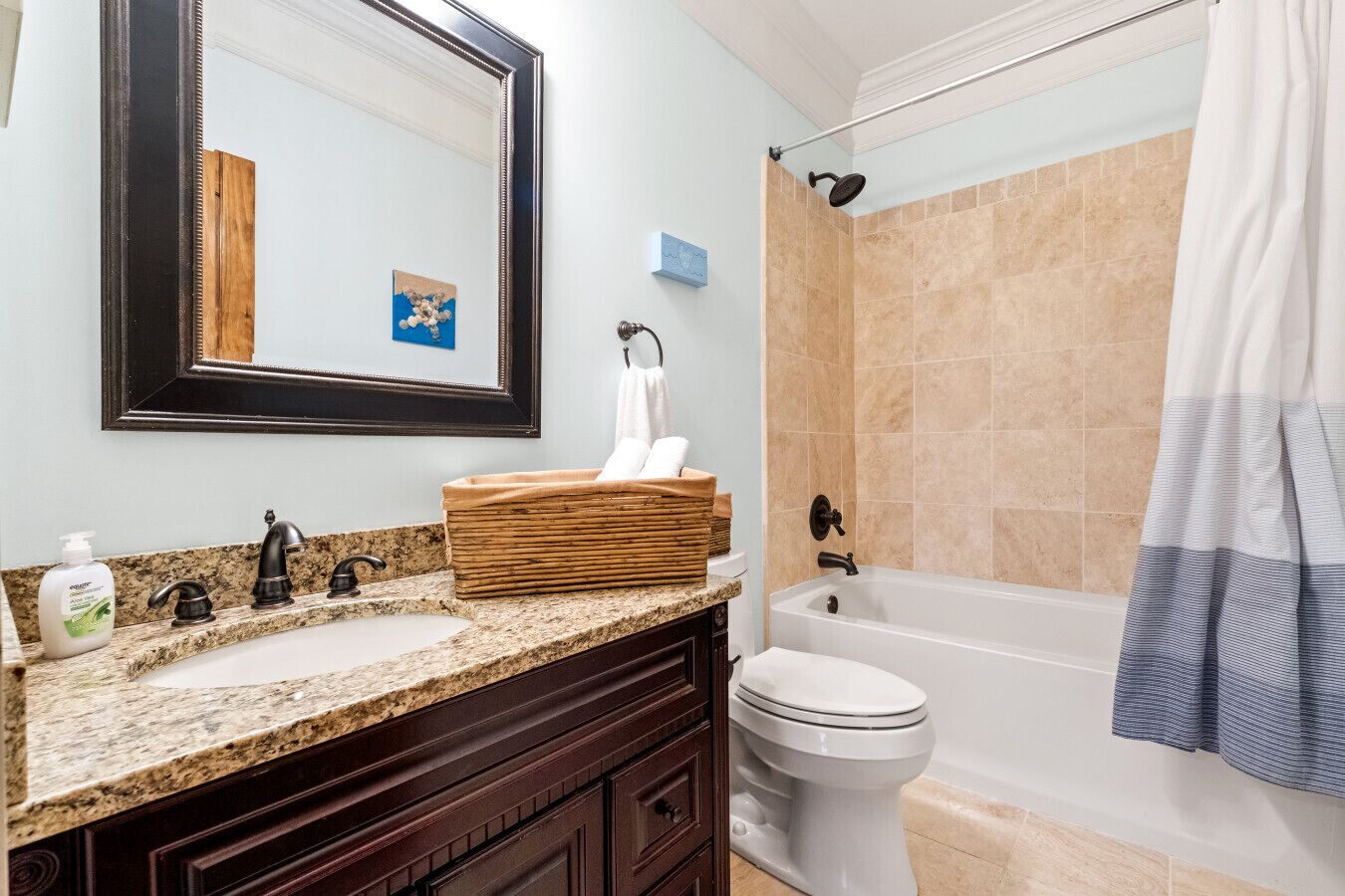 Une salle de bain comprenant un meuble-lavabo à deux vasques, des toilettes, une baignoire et une douche.