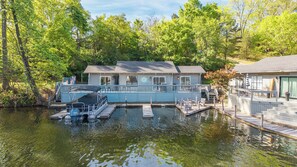 Un chalet au bord du lac, doté d’un quai, d’un abri pour bateau et d’une terrasse.