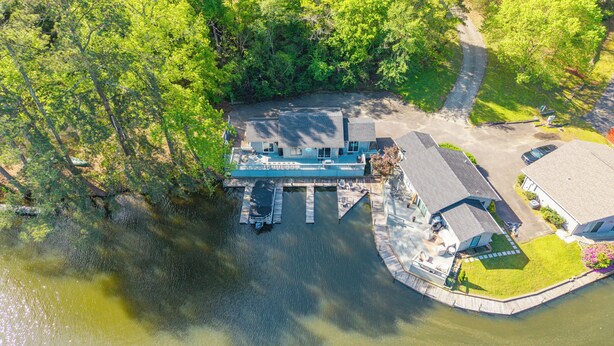 An aerial view of a lakeside property with a dock, a covered seating area, and a parking lot. - Lakefront Getaway w Boat Slip + Patio - Sleeps 8 - Fully Stocked - EV charger (Hot Springs)
