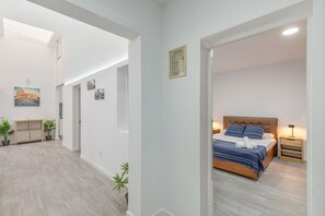 Een moderne slaapkamer met een bed, nachtkastje en een bijzettafeltje.