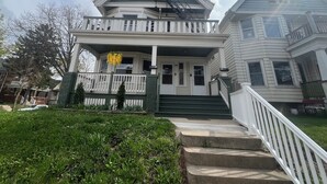 A two-story house with a front porch, a staircase, and a small garden area. - Silver Swan in Riverwest! (Milwaukee)