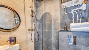 A modern bathroom with a shower, a sink, and a mirror. - Charming Studio Apartment 2P - Nation (Paris)