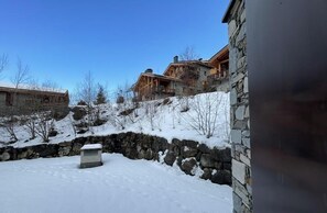 A stone building with a snow-covered ground, a stone wall, and a wooden structure with a balcony. - 1st floor, balcony, tv, ski locker, 69m², Saint Martin de Belleville (Saint-Martin-de-Belleville)