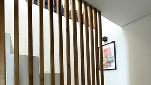 Una escalera con barandillas de madera y un cuadro en la pared.