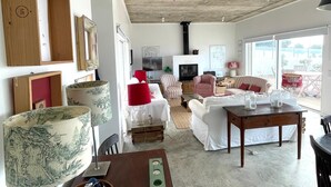 Una sala de estar moderna con un sofá, sillones, una mesa de centro y un televisor.