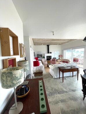 A modern living room with a sofa, armchairs, a coffee table, and a TV. - Praia das Maças - Azenhas do Mar V4 Beachfront Home (Colares)