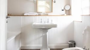 A bathroom with a wooden floor, white walls, a pedestal sink, a toilet, and a mirror. - Wheelwrights Arms (Monkton Combe)