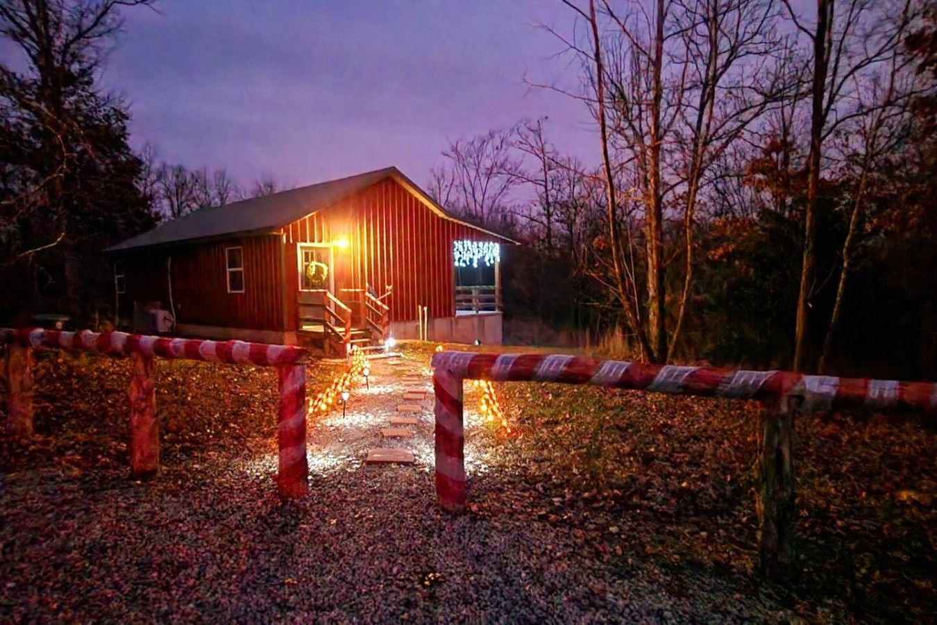 A red building with a sign, a wooden fence, and a pathway leading to the entrance.