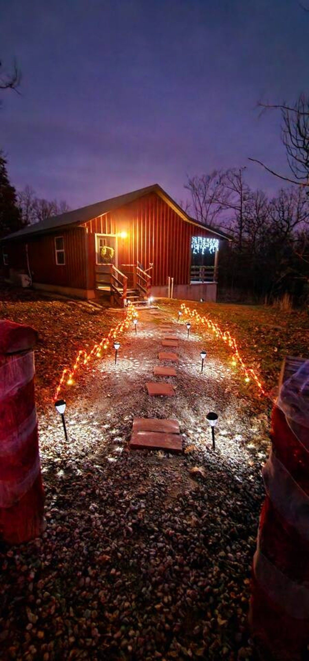 A gravel pathway leading to a wooden building with a staircase.